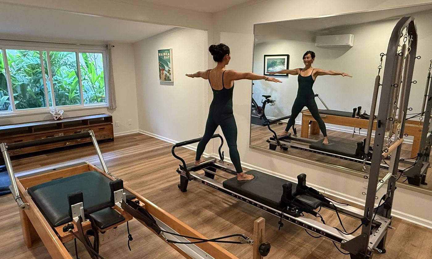 Dr. Moon’s private home studio on Oʻahu, with two Pilates reformers and a wall of mirrors.